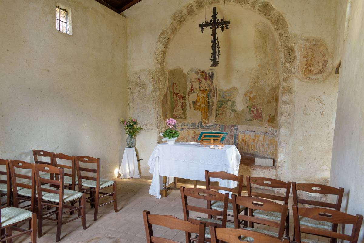 What is a religious retreat: historic stone building with chapel-like windows and wooden pews used as seating